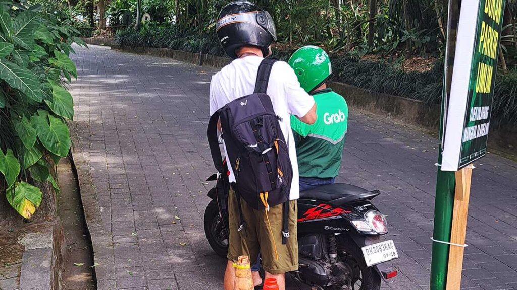 Joan subiéndose en una moto del servicio Grap.