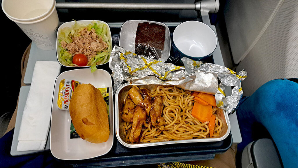 Bandeja de comida de noodles, pan y ensalada en un vuelo con Air China