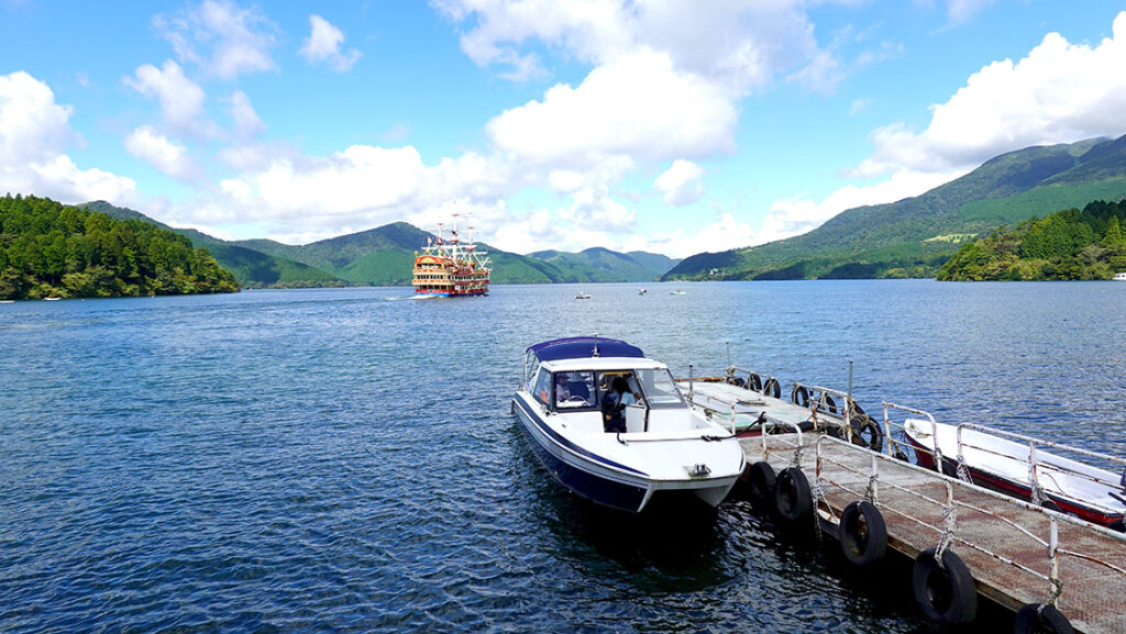 Barco pirata cruzando el lago Ashi visto desde la orilla.
