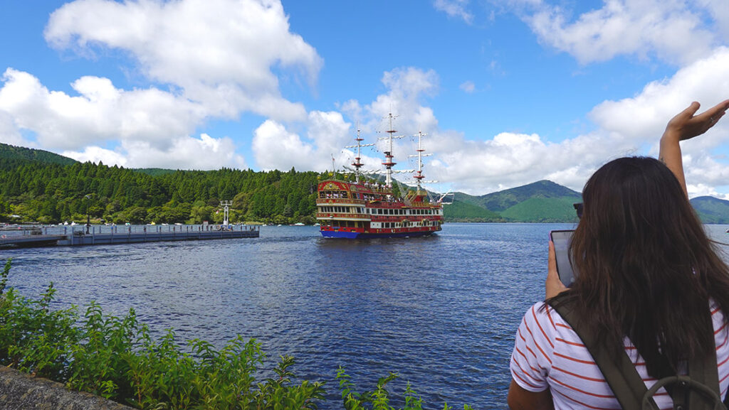 Noelia saludando al barco pirata desde la orilla del Lago Ashi.