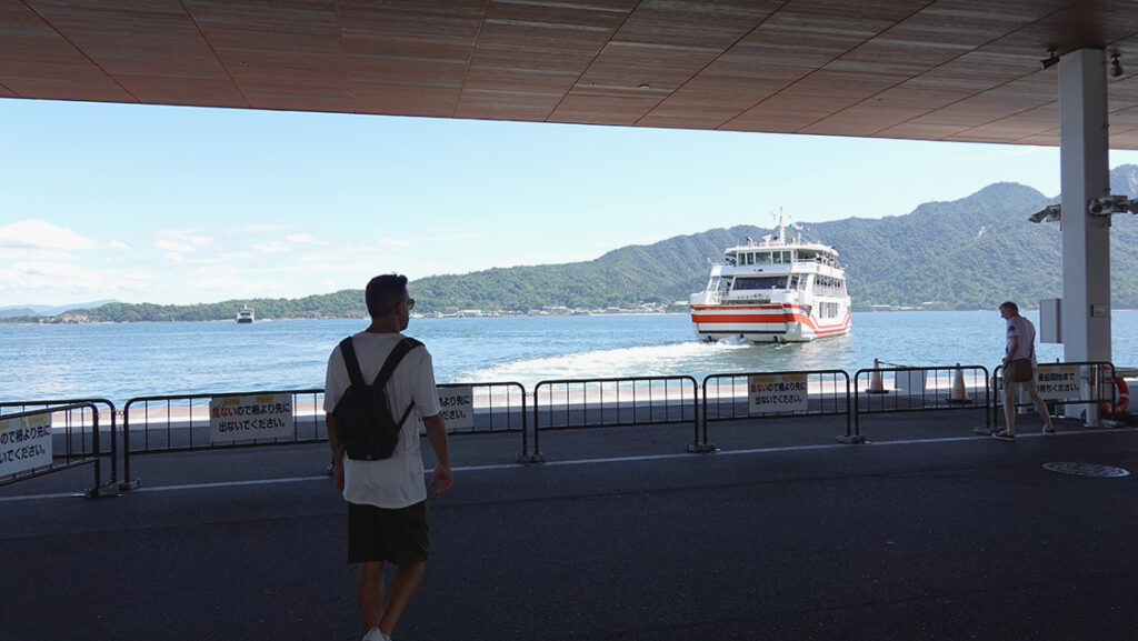 Joan viendo el ferry alejarse hacia la isla de Miyajima desde el muelle.