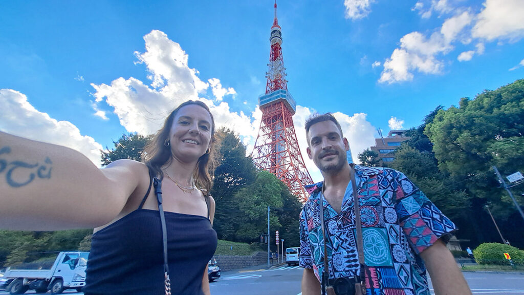 Joan y Noelia abrazados con la silueta de la Torre de Tokio iluminada de noche al fondo.