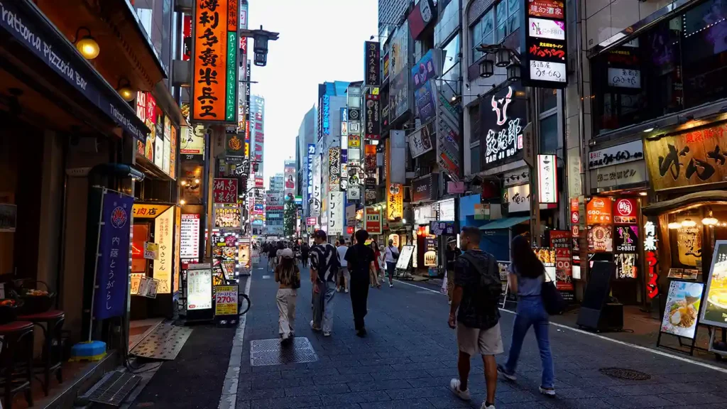 Joan paseando por las calles iluminadas de Kabukicho al atardecer. 