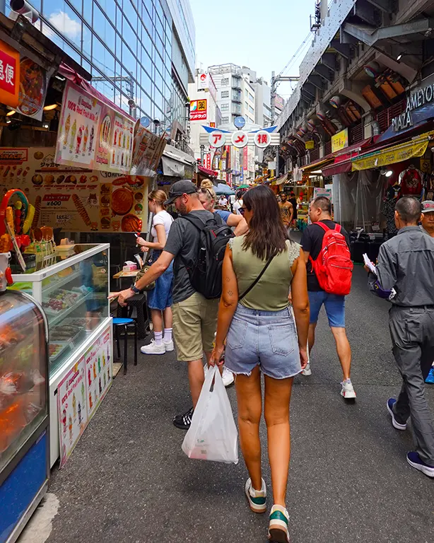 Noelia caminando por un mercado tradicional de Tokio, explorando la ciudad a pie
