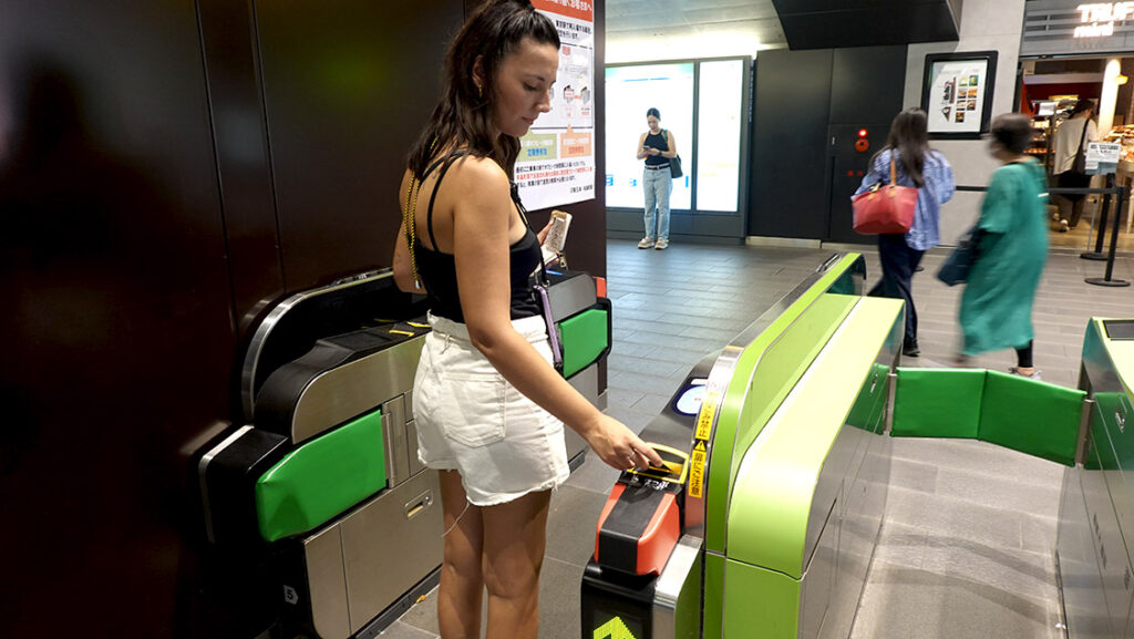 Noelia introduciendo un billete sencillo en el torno de una estación de metro en Tokio