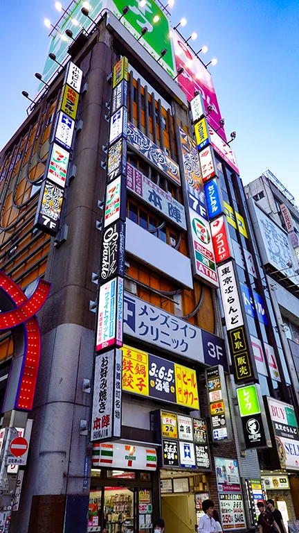Edificio vertical en Kabukicho con carteles de neón en cada planta.