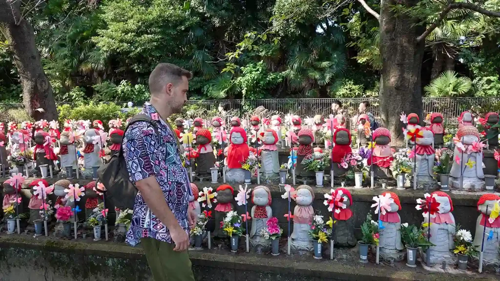 Joan paseando junto a las hileras de estatuas Jizo con gorros de lana roja en Zojoji.
