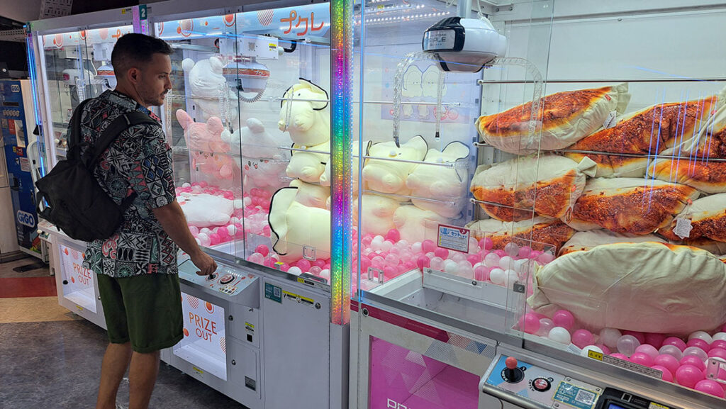 Joan jugando en las máquinas de gancho UFO Catcher de un salón recreativo en Akihabara.