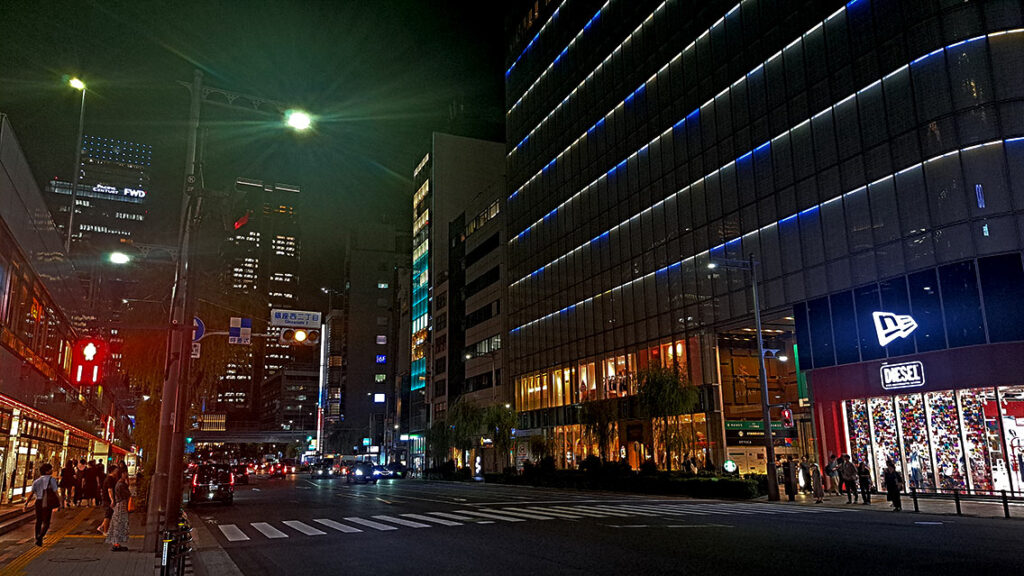 Calles secundarias de Ginza iluminadas por farolas y letreros de neón japoneses por la noche.