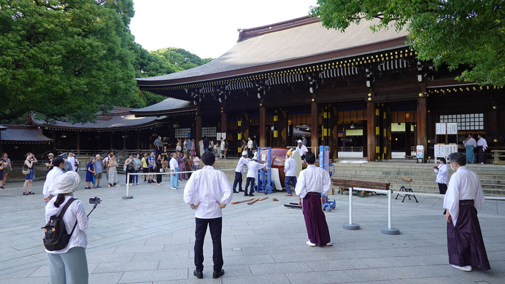 Gente caminando con kimonos y ropas tradicionales japonesas por el patio principal del templo Meiji Jingu.