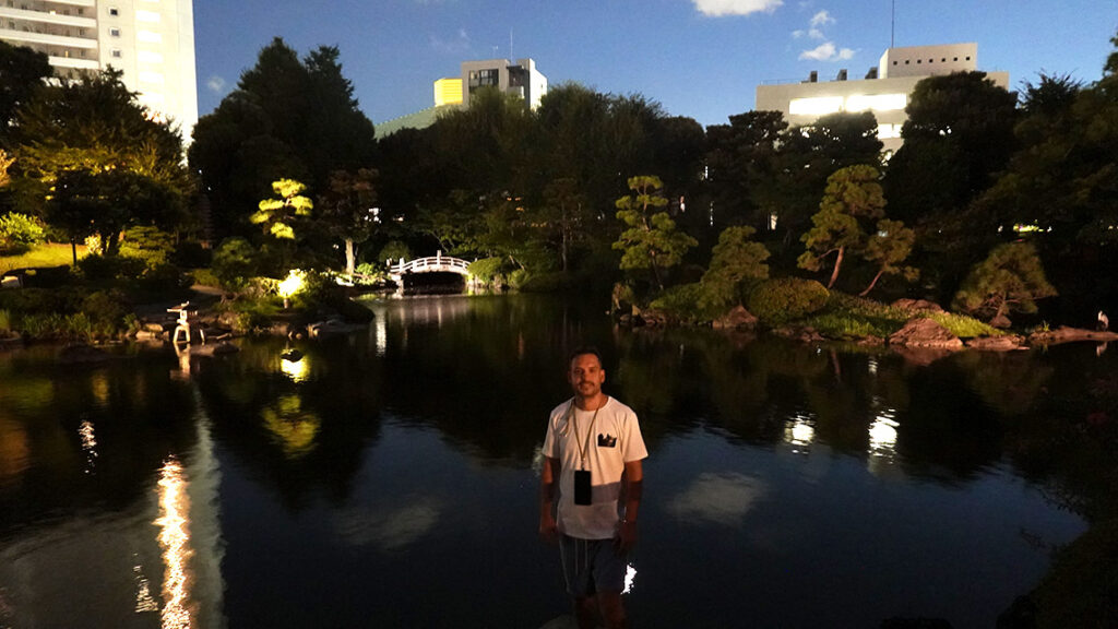 Joan en el puente iluminado del Antiguo Jardín Yasuda de noche en Tokio.
