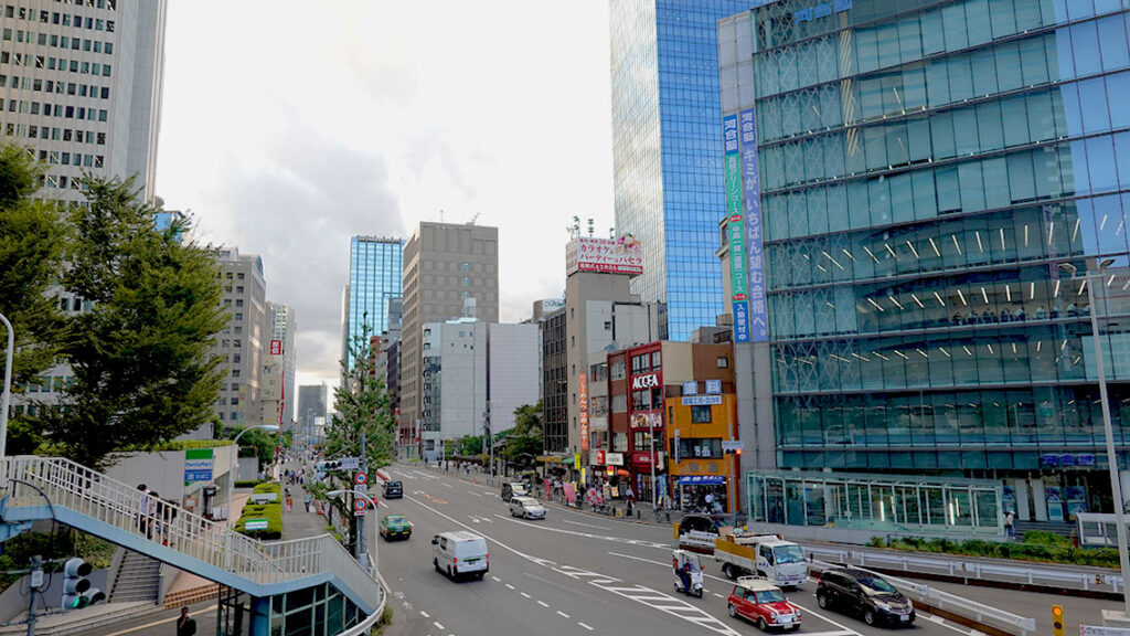 Avenida principal de Shinjuku con rascacielos y tráfico en Tokio.