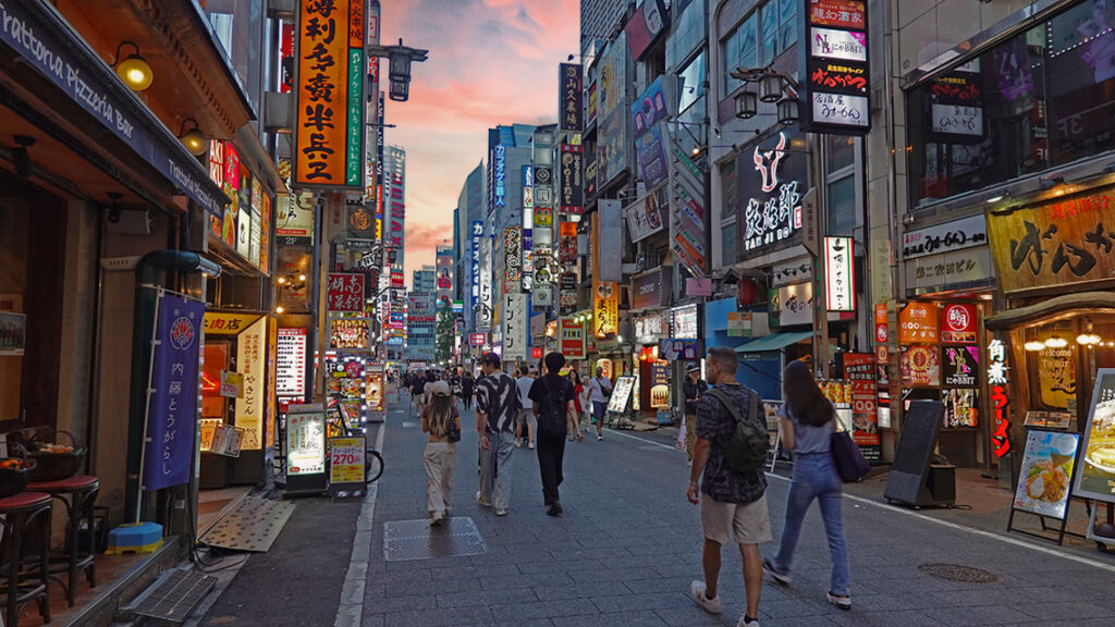 Caminando por una de las calles de Osaka llena de tiendas iluminadas al atardecer