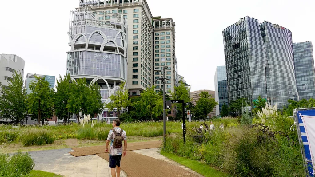 Joan en un parque en Seúl rodeado de rascacielos