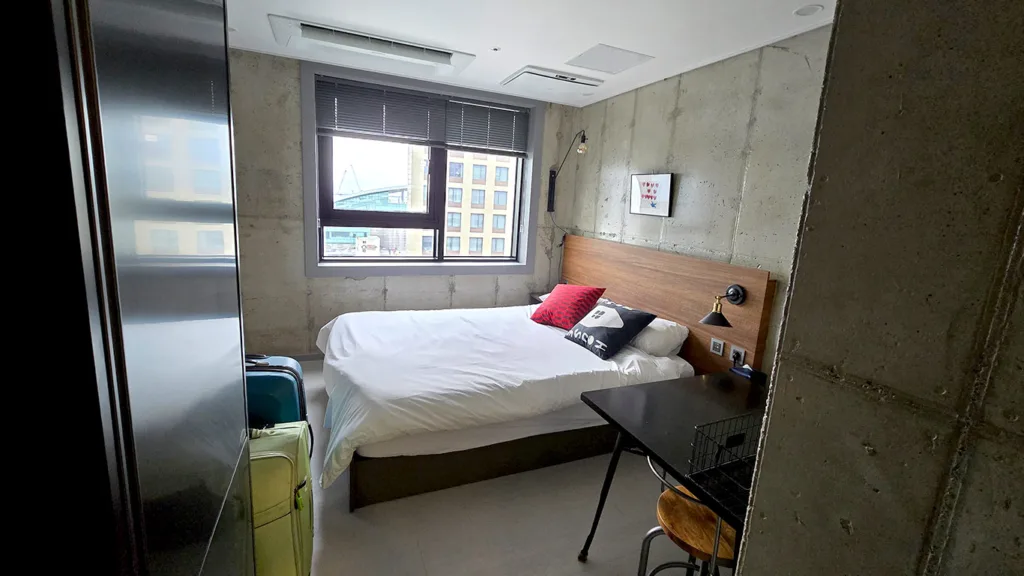 La habitación del Urbanstay Boutique Nampo BIFF con nevera, cocina, y un baño moderno, las vistas hacia la ciudad son espectaculares, y ubicado en la mejor zona donde dormir en Busan, en Nampo