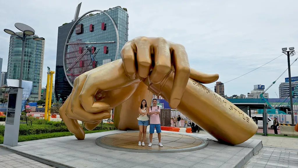 Dos Viajeros Viajando bailando en la Estatua Gangnam Style del cantante PSY