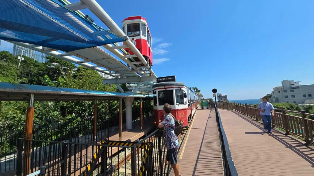 Joan viendo el Sky Capsule y tren panorámico de Busan, un imprescindible que hacer en la ciudad