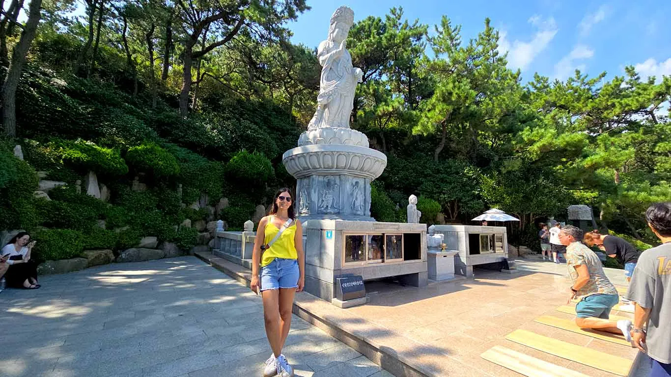 Noelia junto a una escultura de una diosa en el Templo Haedong Yonggungsa.