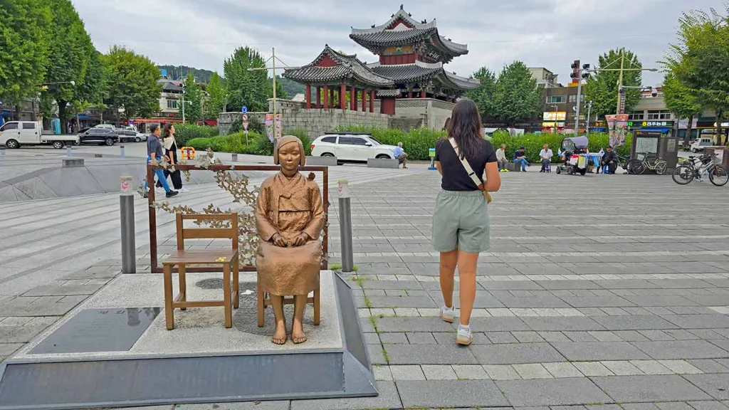 Noelia junto a la estatua de la niña de la paz y de fondo la Pungnammun Gate