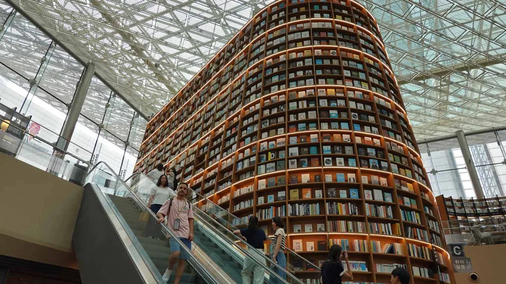 Joan bajando por las escaleras mecánicas en el interior de la Librería Starfield Gangnam en Seúl