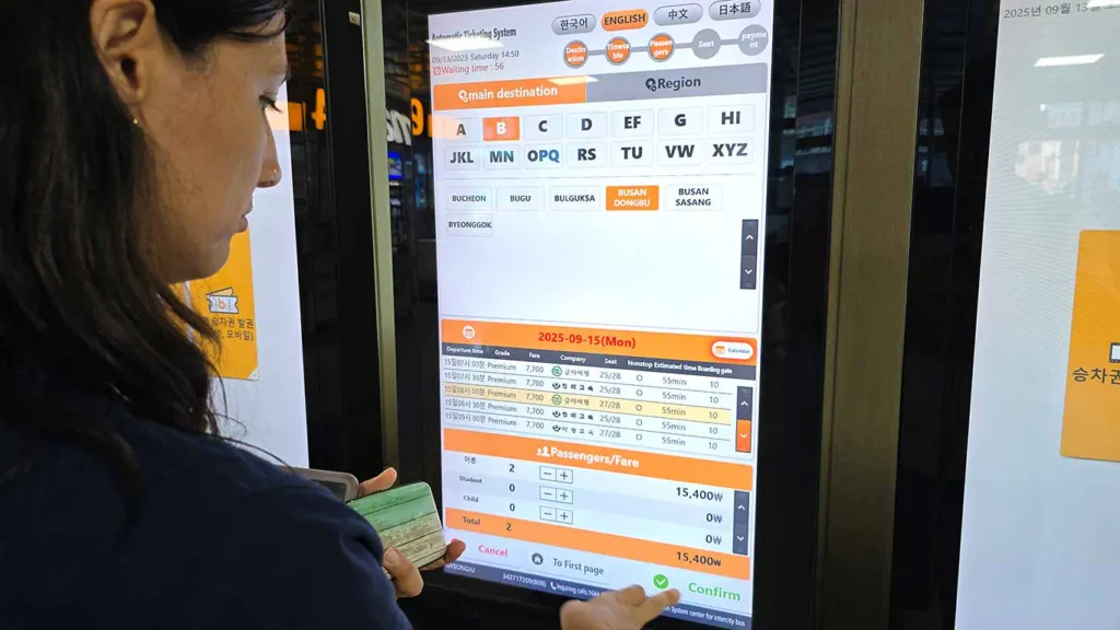 Noelia comprando los tickets del autobús exprés de Gyeongju a Busan en las máquina expendedora de billetes
