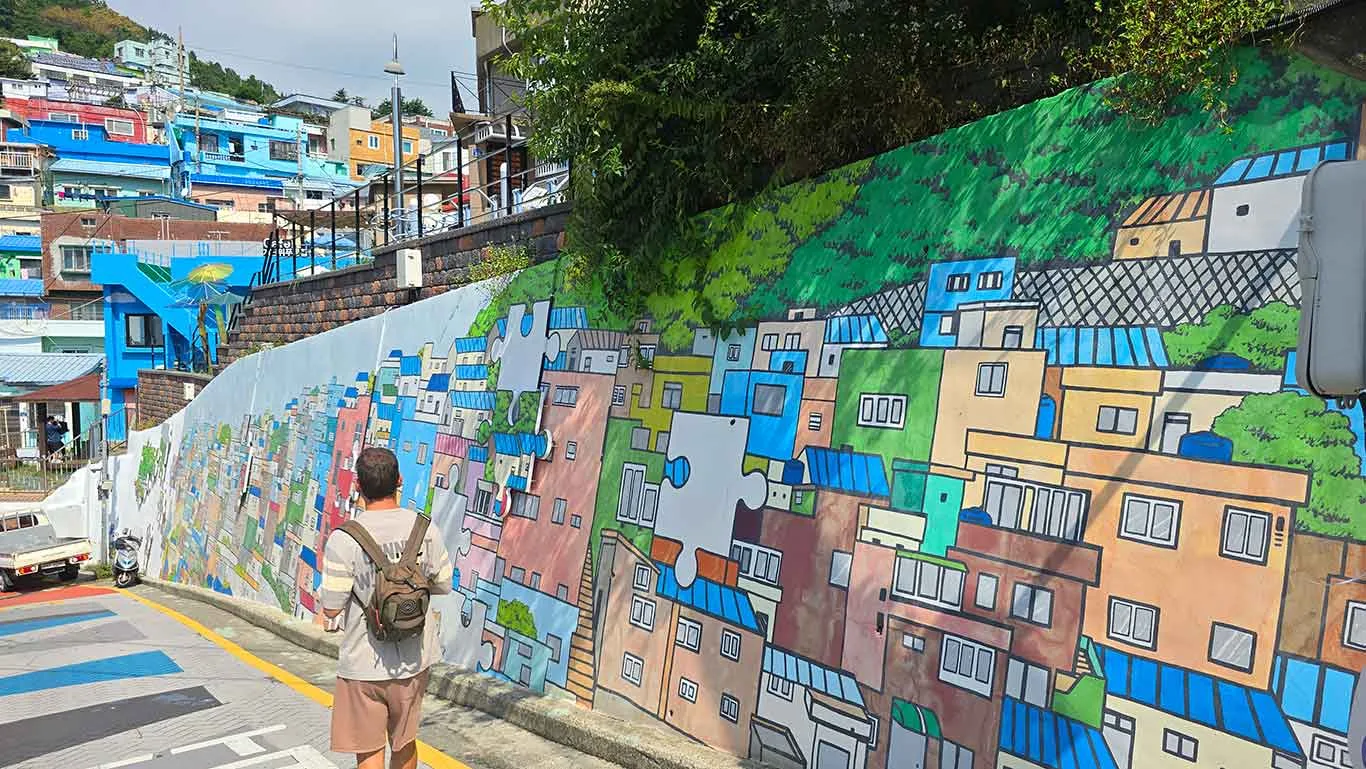 Joan caminando junto a un mural de la Gamcheon Culture Village