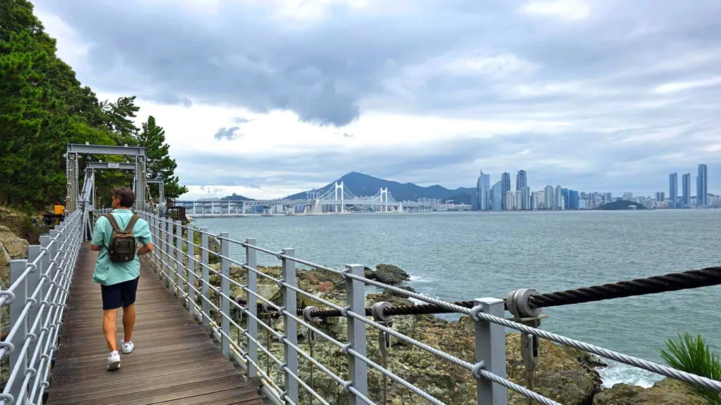 Joan en un puente colgante del sendero Igidae Coastal Trail con vistas a Busan