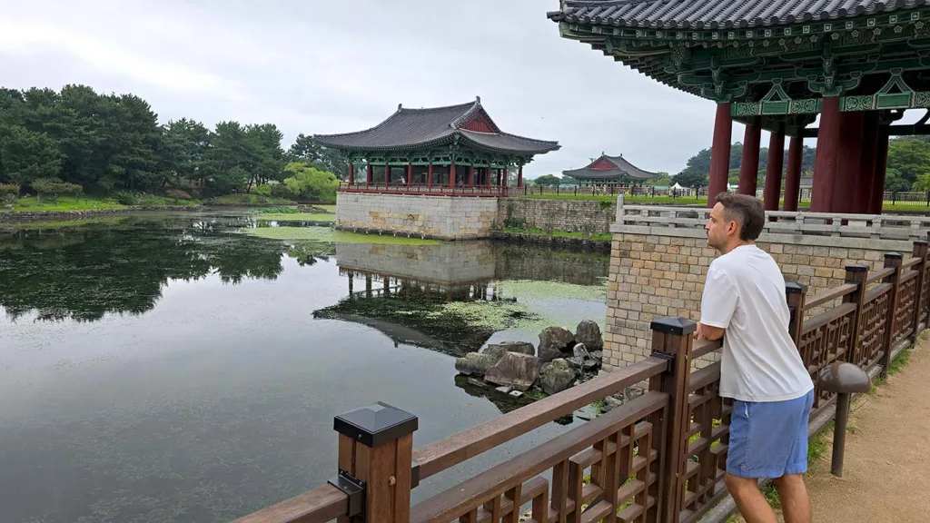 Joan mirando hacia un lago de un templo