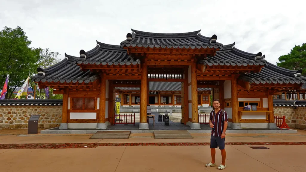 Joan en la entrada principal con techos tradicionales coreanos del recinto