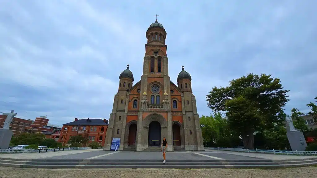 Noelia en el exterior de la catedral de Jeonju con ladrillos rojos de gran tamaño