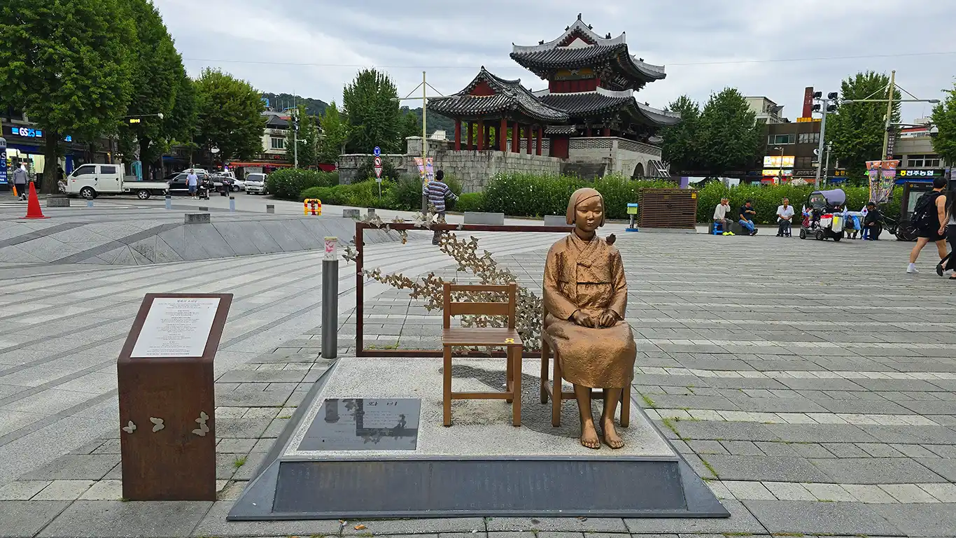 estatua de una niña sentada en una silla