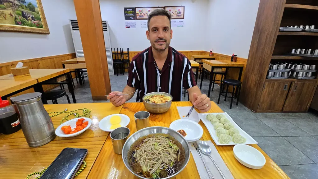 Joan sentado en una mesa del interior del restaurante comiendo