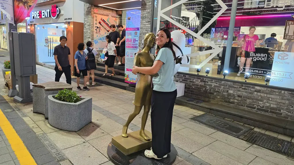 Noelia posando junto a una escultura en la calle comercial de Nampo