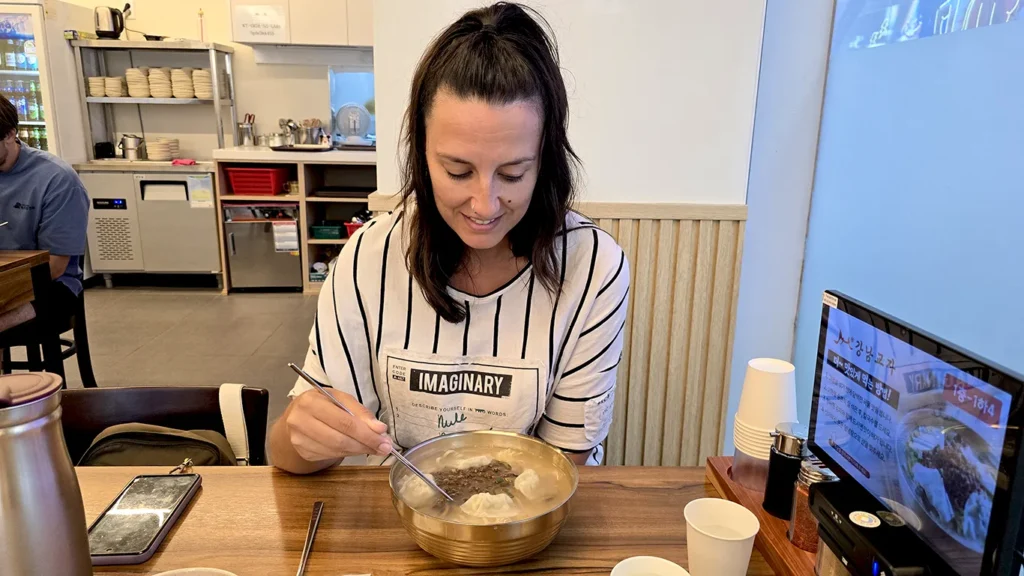 Noelia comiendo en un restaurante de la BIFF Square. un plato de Kalgaksu con Manu