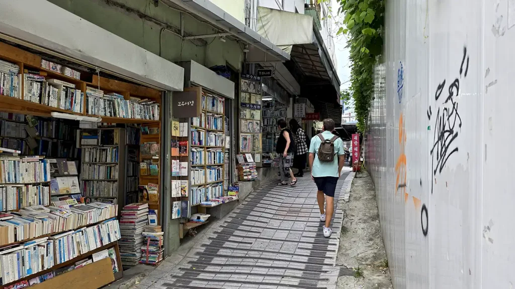 Joan caminando por la calle Bosu Book Street, llena de tiendas de libros