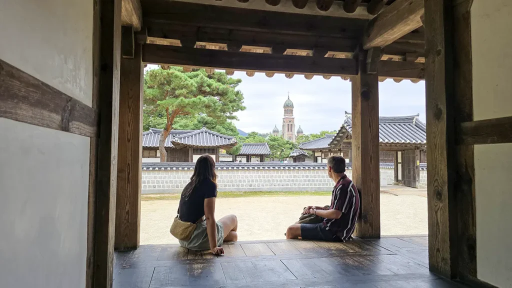 Nosotros sentados en el Santuario Gyeonggijeon en Jeonju, viéndose al fondo una iglesia