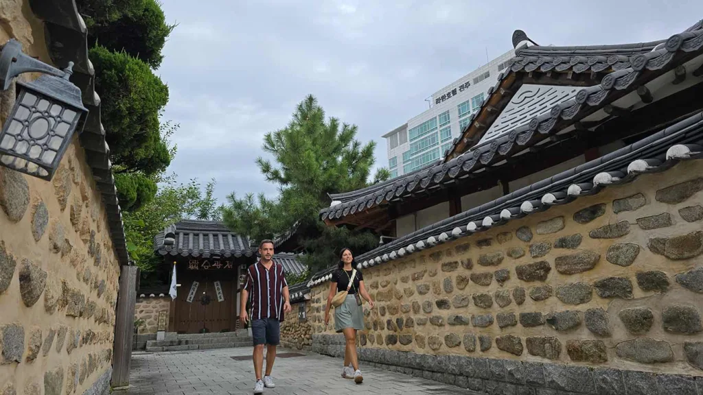 Nosotros paseando por la aldea tradicional hanok, rodeados de esas casas tradicionales con el muro de rocas