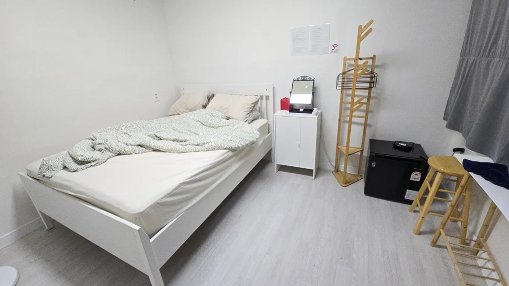El interior de la habitación del Hotel Aha Stay, hay una cama, sillas, nevera y más