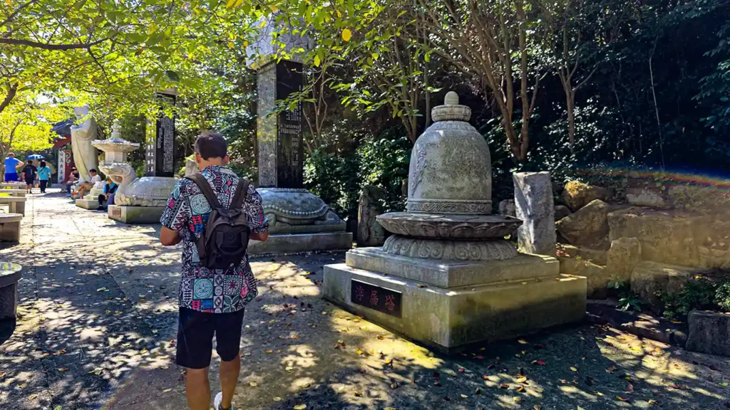 Joan paseando por el camino sagrado al lado de los monolitos y muros de piedras con inscripciones