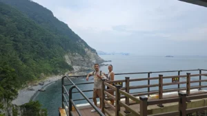 dos personas en un acantilado. uno de los lugares qué ver en yeongdo