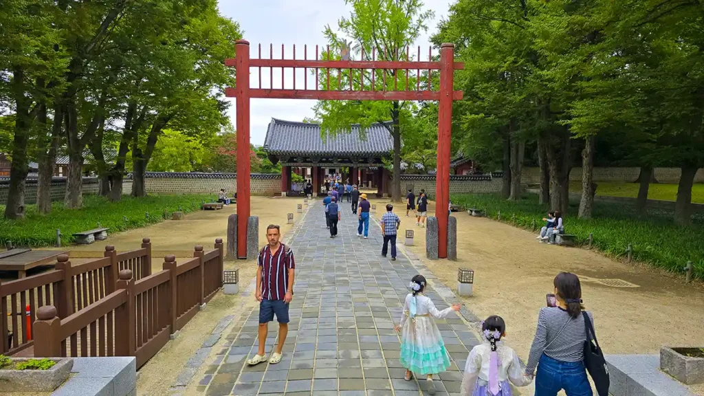 Joan en la entrada del santuario junto a unas niñas vestidas con el traje hanbok tradicional