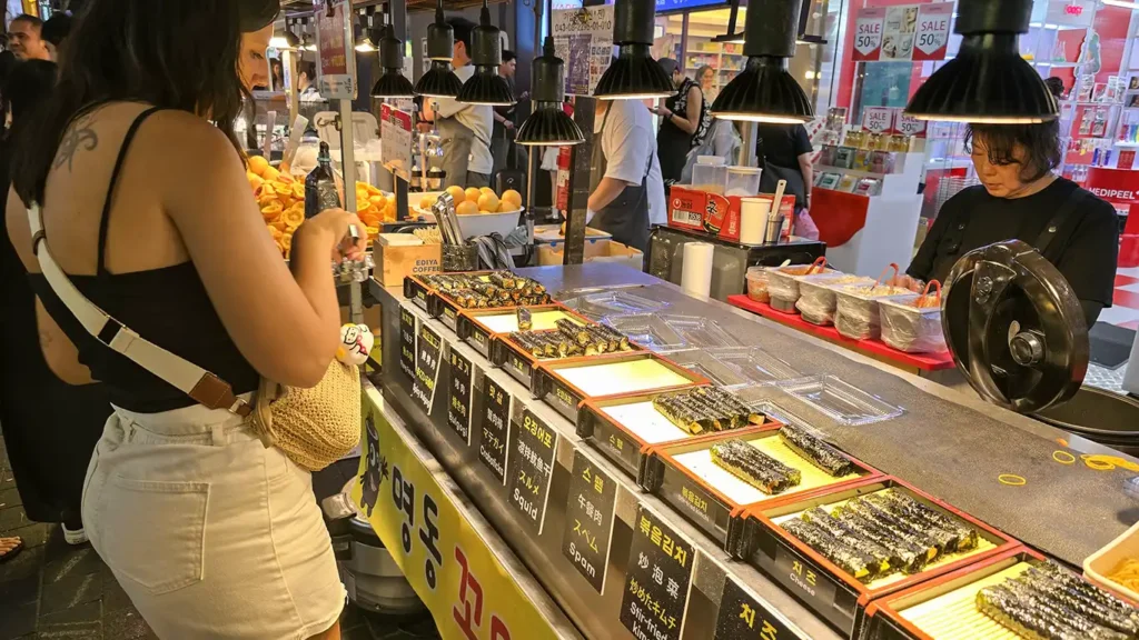 Noelia pidiendo de comer en una parada de sushi