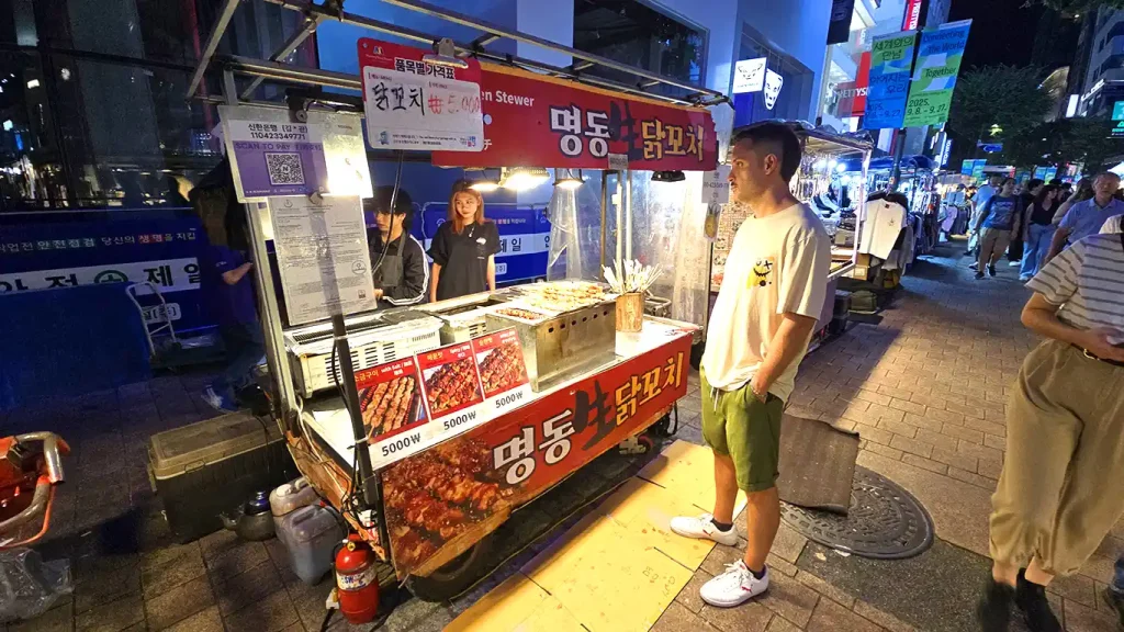 Joan en una parada de brochetas de carne en el Mercado Myeongdong de Seúl por la noche