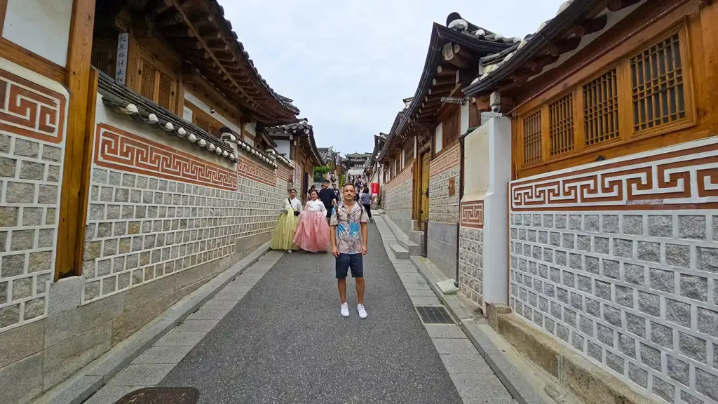 Joan en una calle en Bukchon Hanok Village junto a mujeres vestidas con el traje tradicional coreano Hanbok