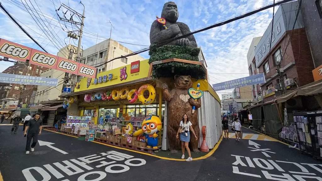 Noelia en un mercado en la calle debajo de una estatua de un gorila