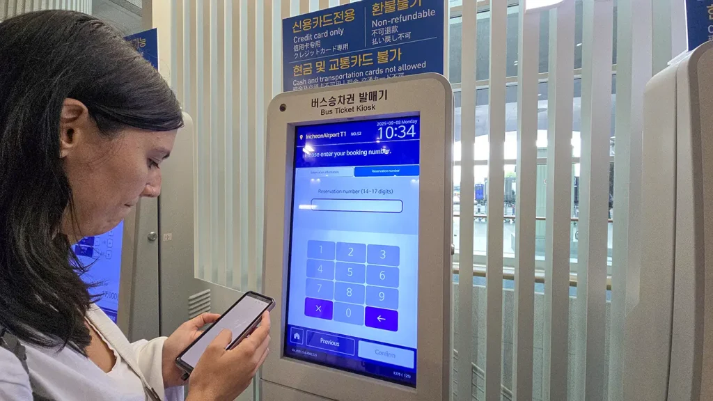 Noelia buscando la reserva del billete en una maquina expendedora en Aeropuerto Incheon