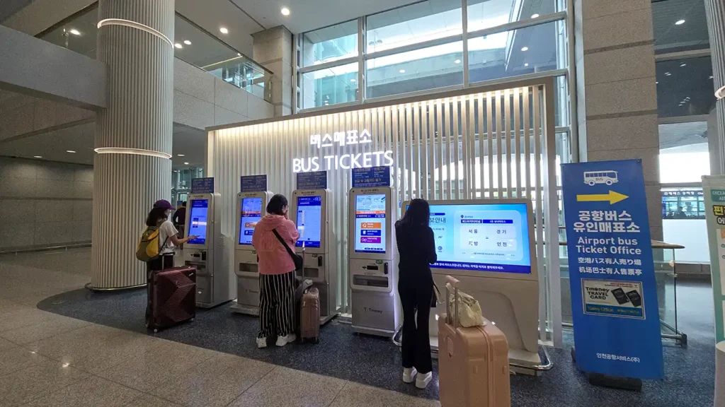 Personas comprando el ticket del bus en el Aeropuerto Incheon de Seúl