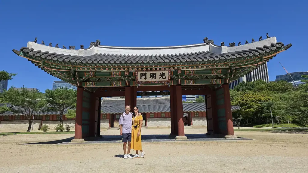 Una de las puertas con columnas rojas y tejado verde y amarillo en el Palacio Deoksugung