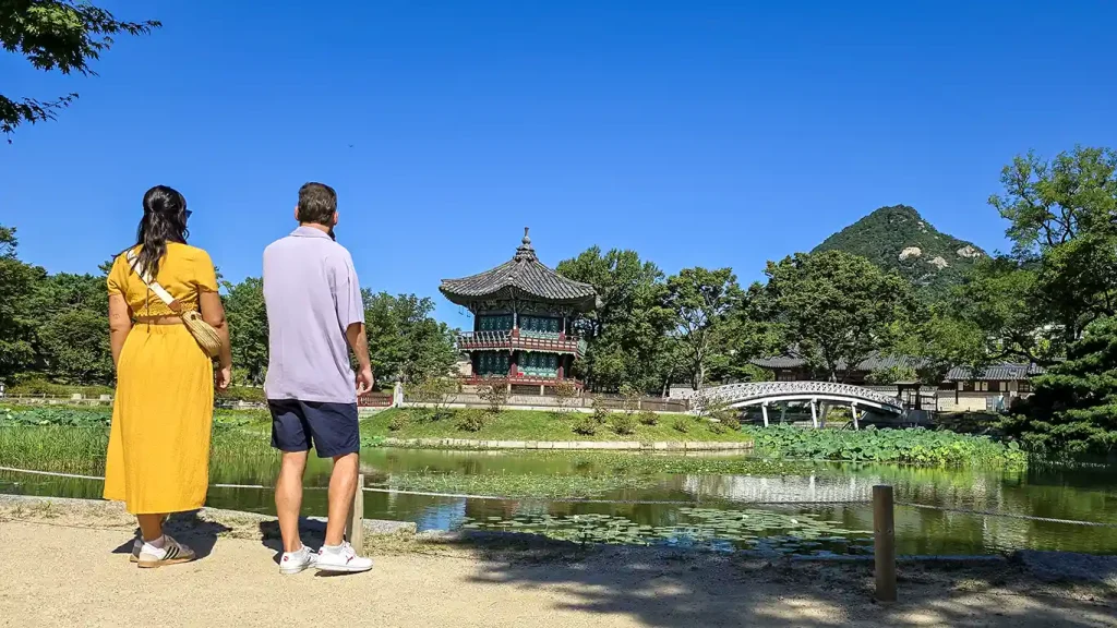 Nosotros viendo el Pabellón Hyangwonjeong rodeado de un estanque con acceso desd eun puente en el Palacio Gyeongbokgung de Seúl