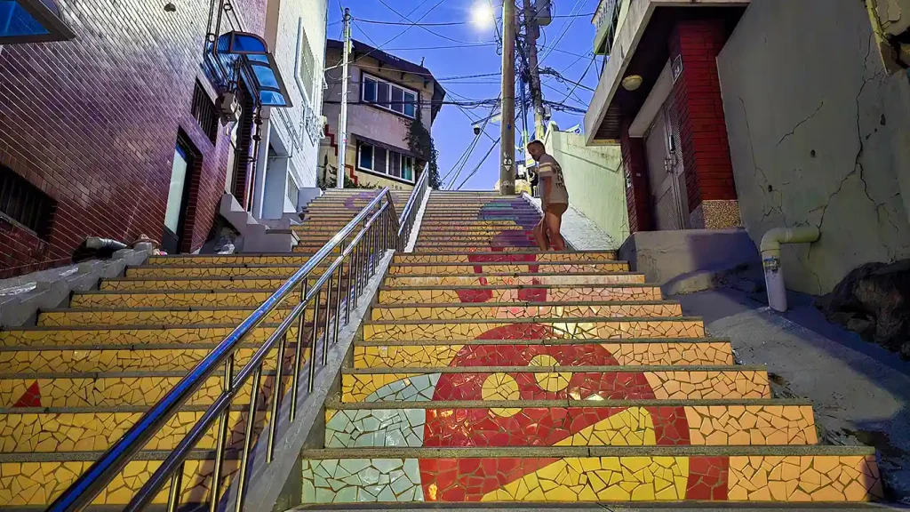 Subiendo escalones de color amarillo con un dibujo de una cara color rojo
